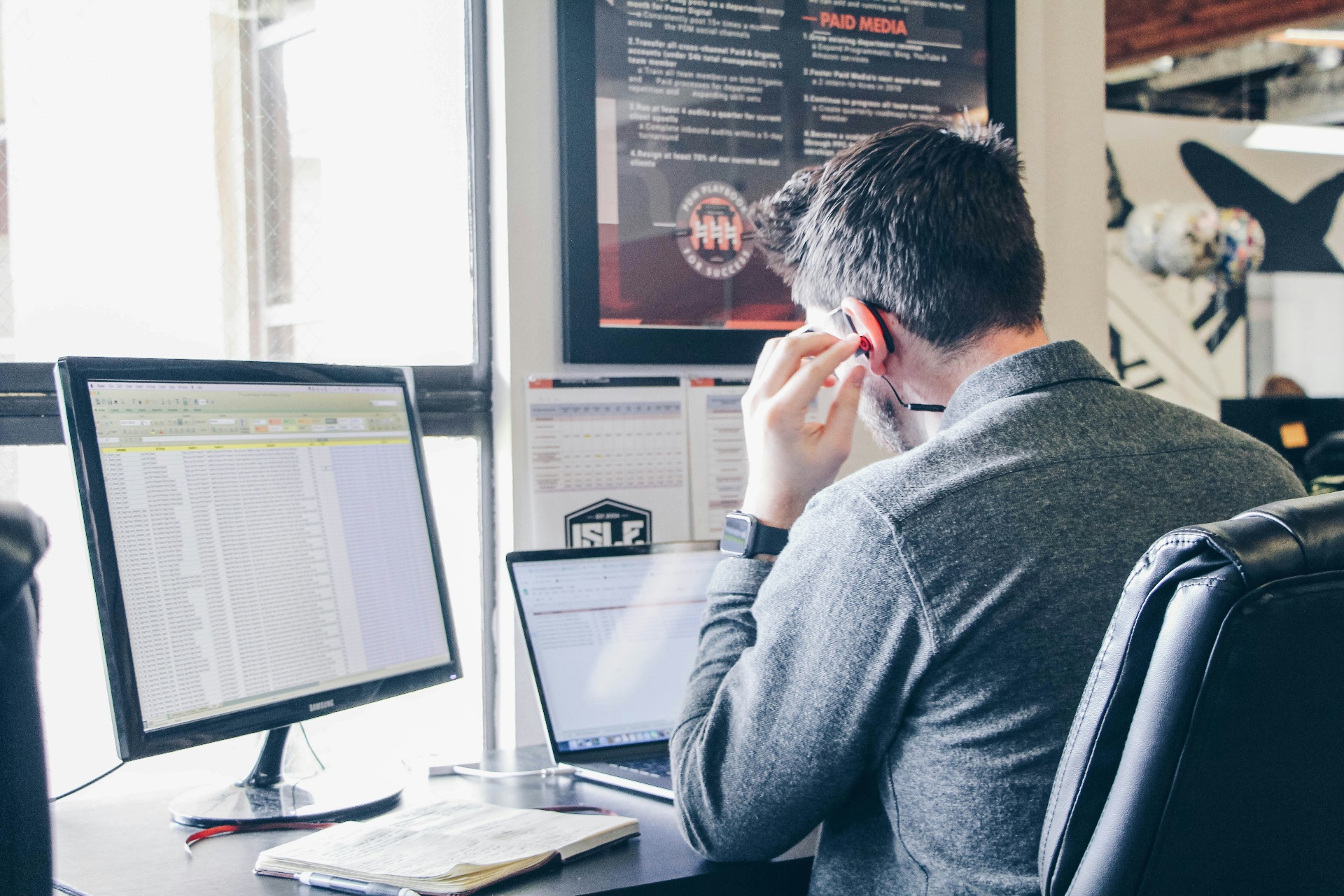 Home service business owner reviewing ServiceTitan pricing data on a laptop at a wooden desk.