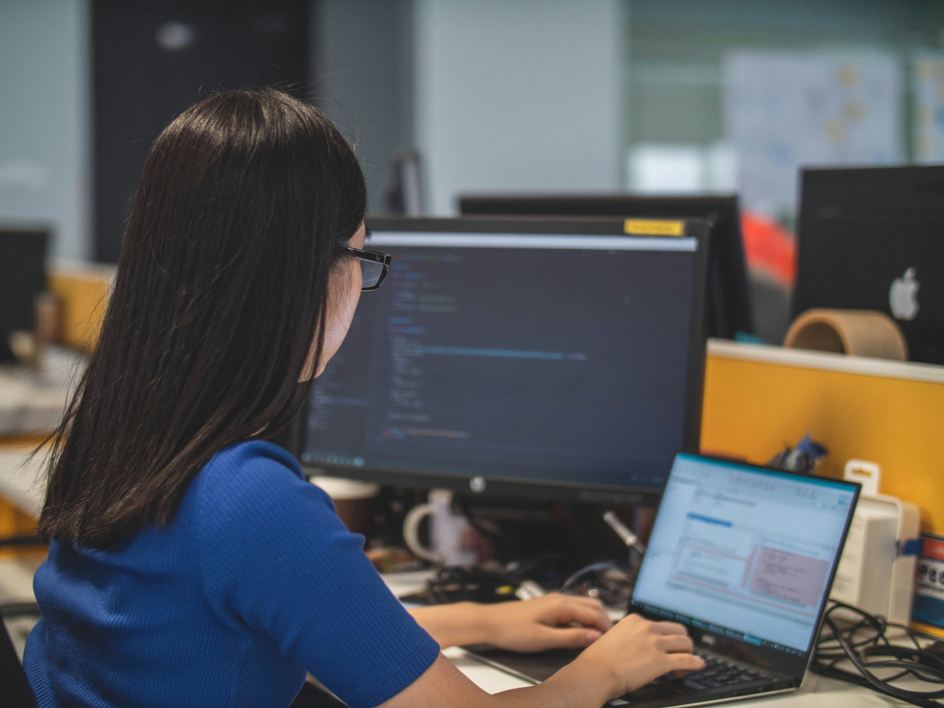 Analyst reviewing home service business reporting data on a desktop monitor with a laptop open beside it.